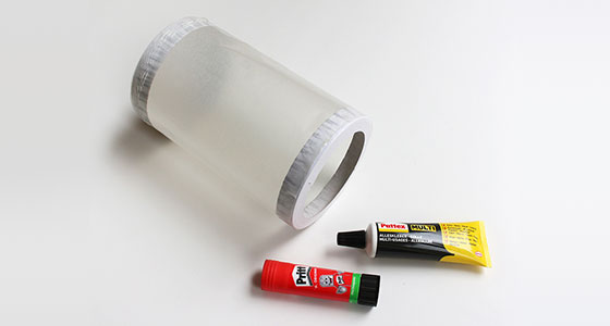 Transparente Folie, Klebstofftube und Klebestift